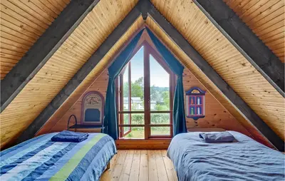 two beds in a room with a large window at Nice Home In Løgstrup With Wifi in Løgstrup