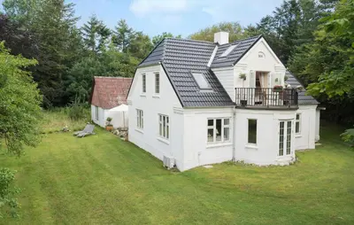 a white house with a balcony on a yard at Pet Friendly Home In Roslev With Wifi in Roslev