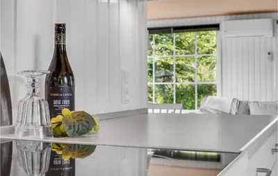a bottle of wine sitting on a counter in a kitchen at Beautiful Home In Vinderup With Kitchen in Vinderup