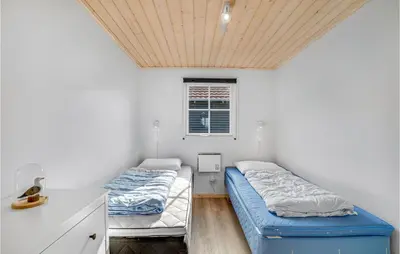 two beds in a room with a wooden ceiling at Beautiful Home In Vinderup With Kitchen in Vinderup