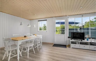 a dining room with a table and chairs and a television at Beautiful Home In Vinderup With Kitchen in Vinderup