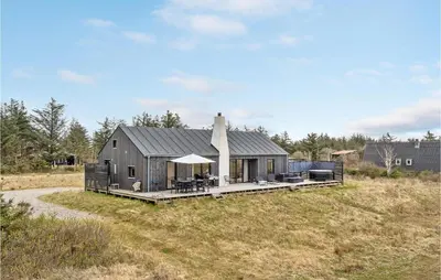 a black house on a hill with a deck at 3 Bedroom Stunning Home In Thyholm in Thyholm