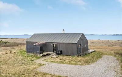 a black building in the middle of a field at 3 Bedroom Stunning Home In Thyholm in Thyholm