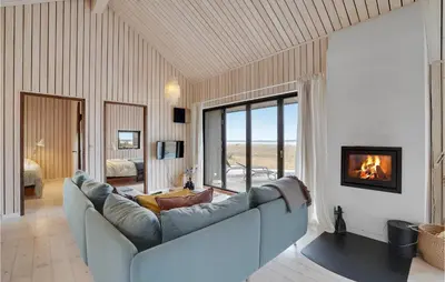 a living room with a couch and a fireplace at 3 Bedroom Stunning Home In Thyholm in Thyholm