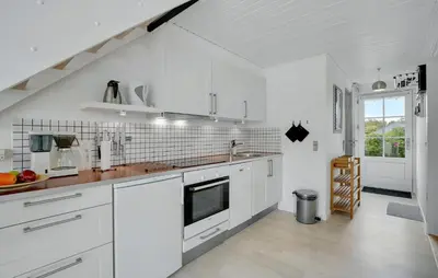 a white kitchen with white cabinets and a sink at Agger Havn Feriecenter in Vestervig