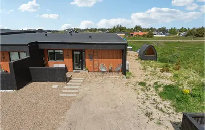 a small house with a black roof on a field at 3 Bedroom Amazing Home In Thisted in Thisted