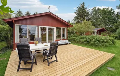 a wooden deck with two chairs and a house at 3 Bedroom Cozy Home In Spøttrup in Spottrup