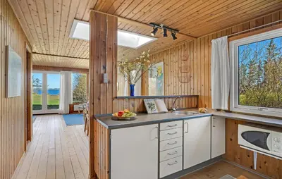 a kitchen with wood paneling and a sink and a window at 3 Bedroom Cozy Home In Spøttrup in Spottrup