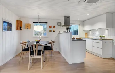 a kitchen and dining room with a table and chairs at Cozy Home In Pandrup With Kitchen in Pandrup