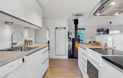 a kitchen with white cabinets and a sink at Cozy Home In Pandrup With Kitchen in Pandrup