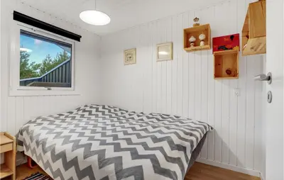 a bed in a room with white walls and a window at Cozy Home In Pandrup With Kitchen in Pandrup