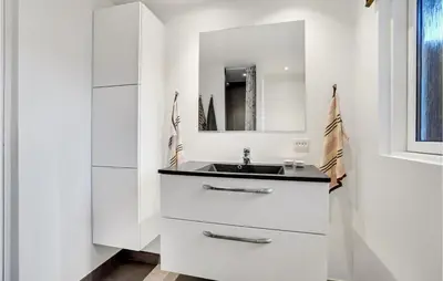 a white bathroom with a sink and a mirror at Cozy Home In Pandrup With Kitchen in Pandrup