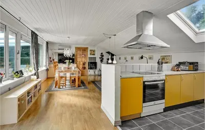 a kitchen with yellow and white cabinets and a table at Lovely Home In Roslev With Wifi in Roslev