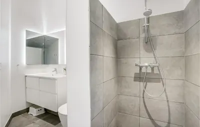 a white bathroom with a shower and a sink at Amazing Home In Blokhus With Sauna in Blokhus