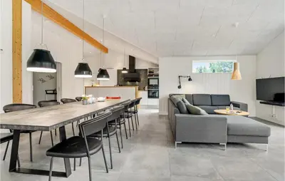 a kitchen and living room with a large table and chairs at Amazing Home In Blokhus With Sauna in Blokhus