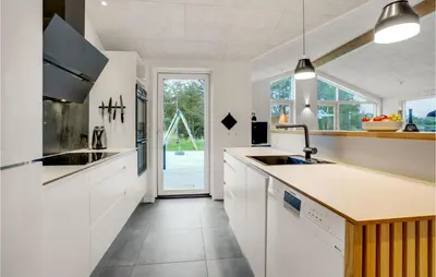 a kitchen with white cabinets and a sink at Amazing Home In Blokhus With Sauna in Blokhus