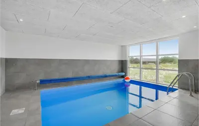 a swimming pool in a room with a large window at Lovely Home In Thisted in Thisted