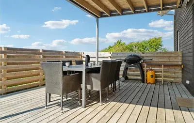 a deck with a table and chairs and a grill at Lovely Home In Thisted in Thisted