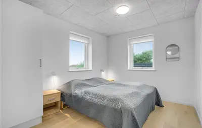 a white bedroom with a bed and two windows at Lovely Home In Thisted in Thisted