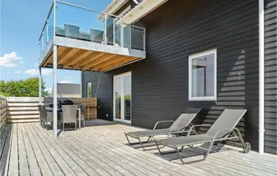 a deck with chairs and a table and a balcony at Lovely Home In Thisted in Thisted