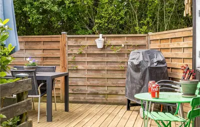 a patio with tables and chairs and a fence at Cozy Home In Roslev With Wifi in Roslev