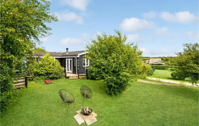 a yard with two chairs and a table in the grass at Cozy Home In Roslev With Wifi in Roslev