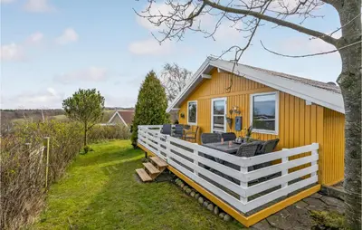 a yellow tiny house with a white railing at Lovely Home In Roslev With Kitchen in Roslev