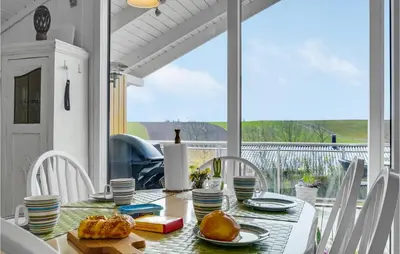 a dining room table with a view of the ocean at Lovely Home In Roslev With Kitchen in Roslev