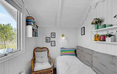 a small bedroom with a bed and a chair at Lovely Home In Roslev With Kitchen in Roslev
