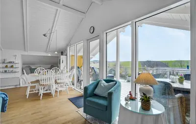 a living room with a blue chair and a table at Lovely Home In Roslev With Kitchen in Roslev