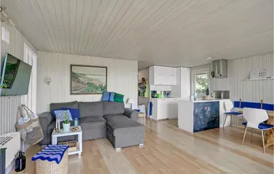 a living room with a couch and a kitchen at Lovely Home In Spøttrup in Spottrup