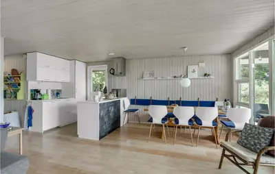 a kitchen with white cabinets and a table and chairs at Lovely Home In Spøttrup in Spottrup