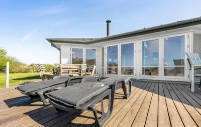 a deck with chairs and tables on a house at Stunning Home In Vestervig With Sauna in Vestervig