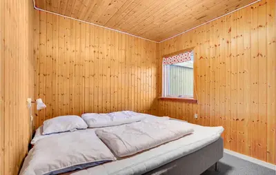 a bedroom with a bed in a wooden wall at Gorgeous Home In Harboøre With Wifi in Harboør