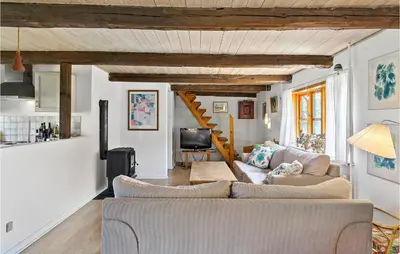 a living room with a couch and a tv at Cozy Home In Nykøbing M With Kitchen in Tæbring