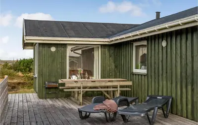 a green house with a table and chairs on a patio at Awesome Home In Lemvig With Wifi in Lemvig