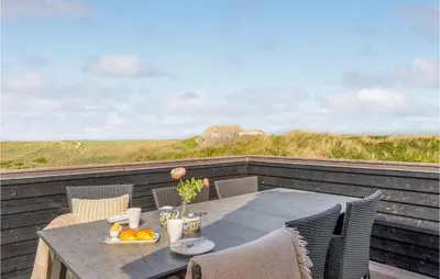 a table with a bowl of fruit on top of a balcony at Stunning Home In Harboøre With Sauna in Harboør