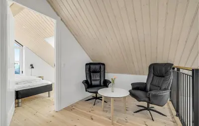 two chairs and a table in a room with a bed at Stunning Home In Harboøre With Sauna in Harboør