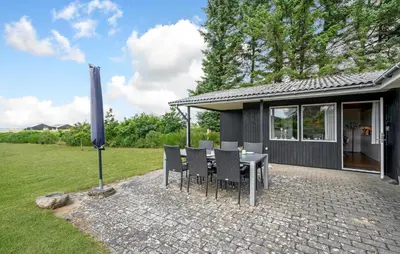 a patio with a table and chairs in front of a house at Beautiful Home In Spøttrup With Kitchen in Spottrup