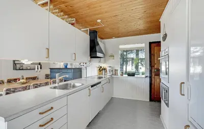 a kitchen with white cabinets and a wooden ceiling at Beautiful Home In Spøttrup With Kitchen in Spottrup