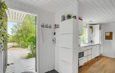a kitchen with white appliances and a sliding glass door at Nice Home In Roslev With Kitchen in Roslev
