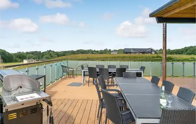 a deck with a table and chairs and a grill at Lovely Home In Spøttrup With Wifi in Spottrup