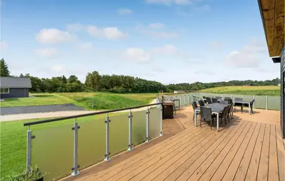 a deck with a table and chairs on it at Lovely Home In Spøttrup With Wifi in Spottrup