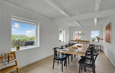 a dining room with a table and black chairs at Amazing Home In Vestervig With Sauna in Vestervig