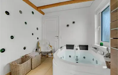 a white bathroom with a tub and a chair at Amazing Home In Vestervig With Sauna in Vestervig