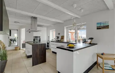 a kitchen with white cabinets and black counter tops at Amazing Home In Vestervig With Sauna in Vestervig