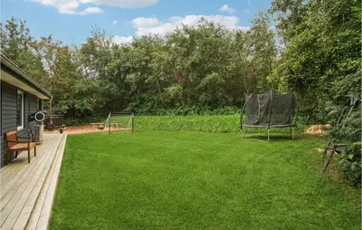 a lawn with a chair on the side of a house at Nice Home In Hurup Thy With Wifi in Sindrup