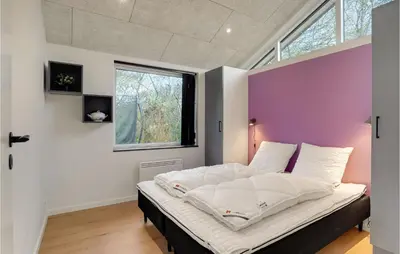 a bedroom with a large bed with a purple accent wall at Nice Home In Hurup Thy With Wifi in Sindrup