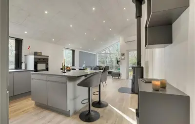 a kitchen with a counter and a bar with chairs at Nice Home In Hurup Thy With Wifi in Sindrup
