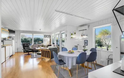 a kitchen and living room with a table and chairs at 4 Bedroom Stunning Home In Thyholm in Thyholm